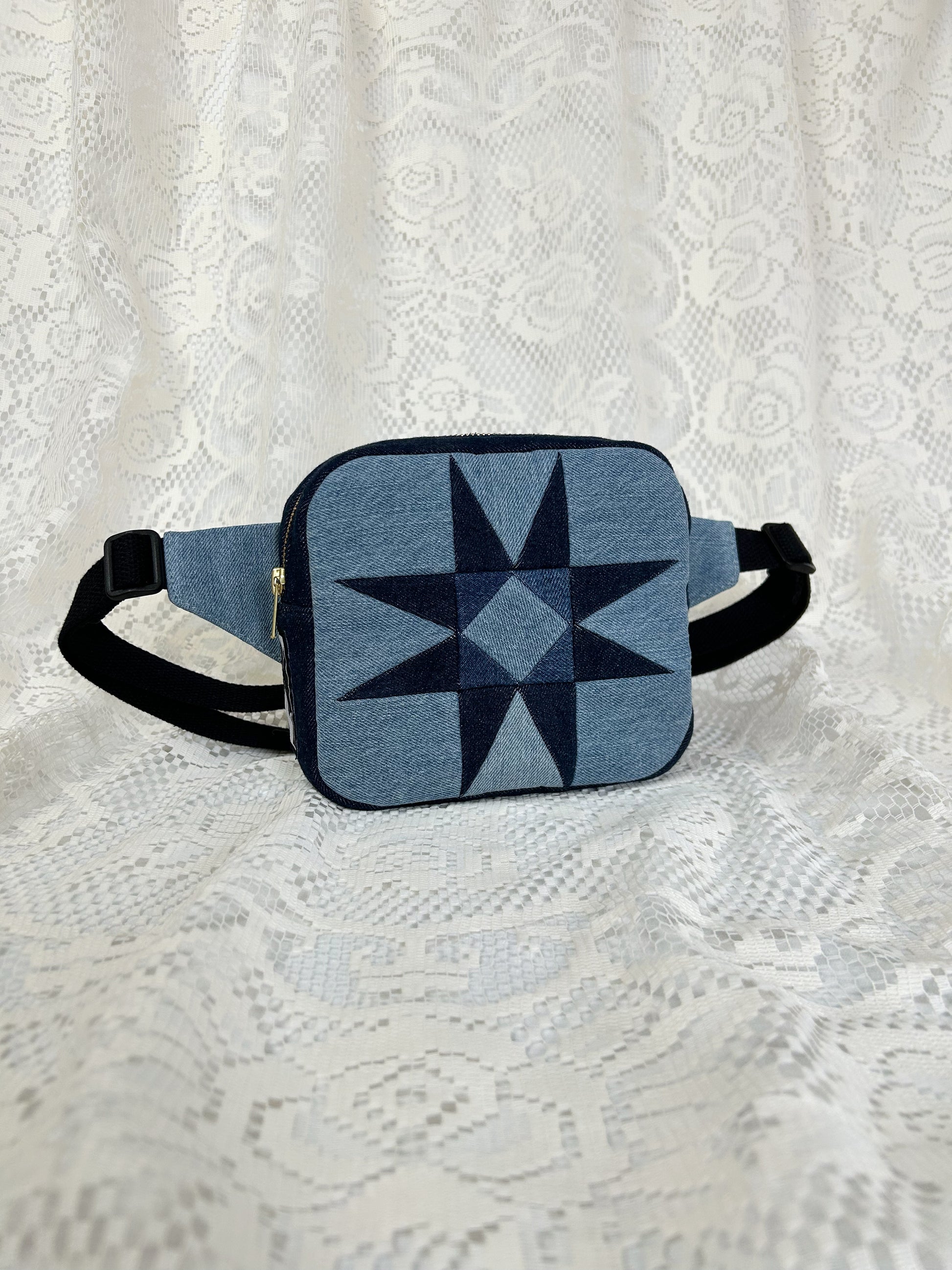 Two tone blue denim fanny pack with a patchwork star pattern on a white lace background