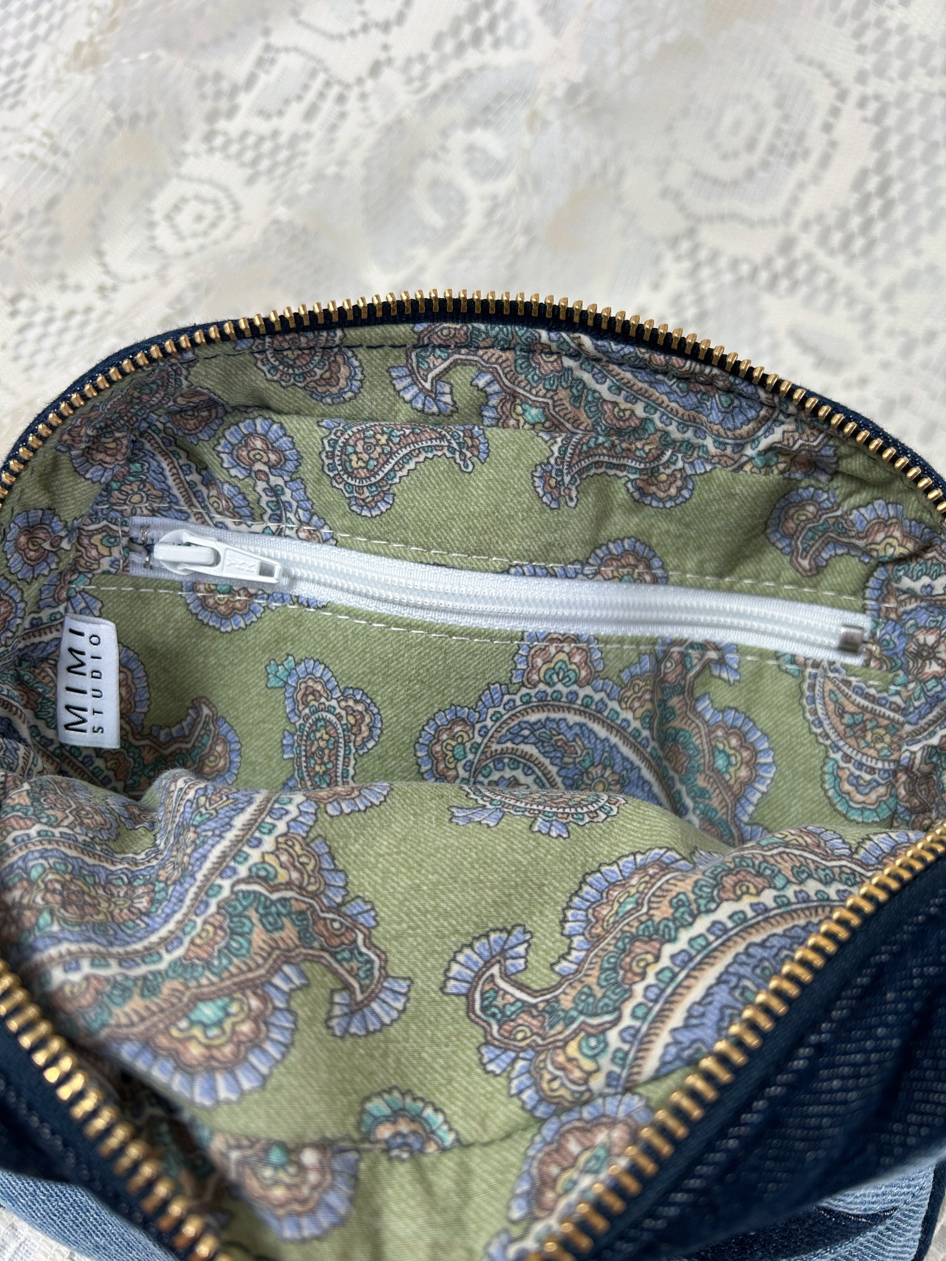 Cotton paisley lining fabric with a zippered pocket for the two tone blue denim fanny pack with a patchwork star pattern on a white lace background