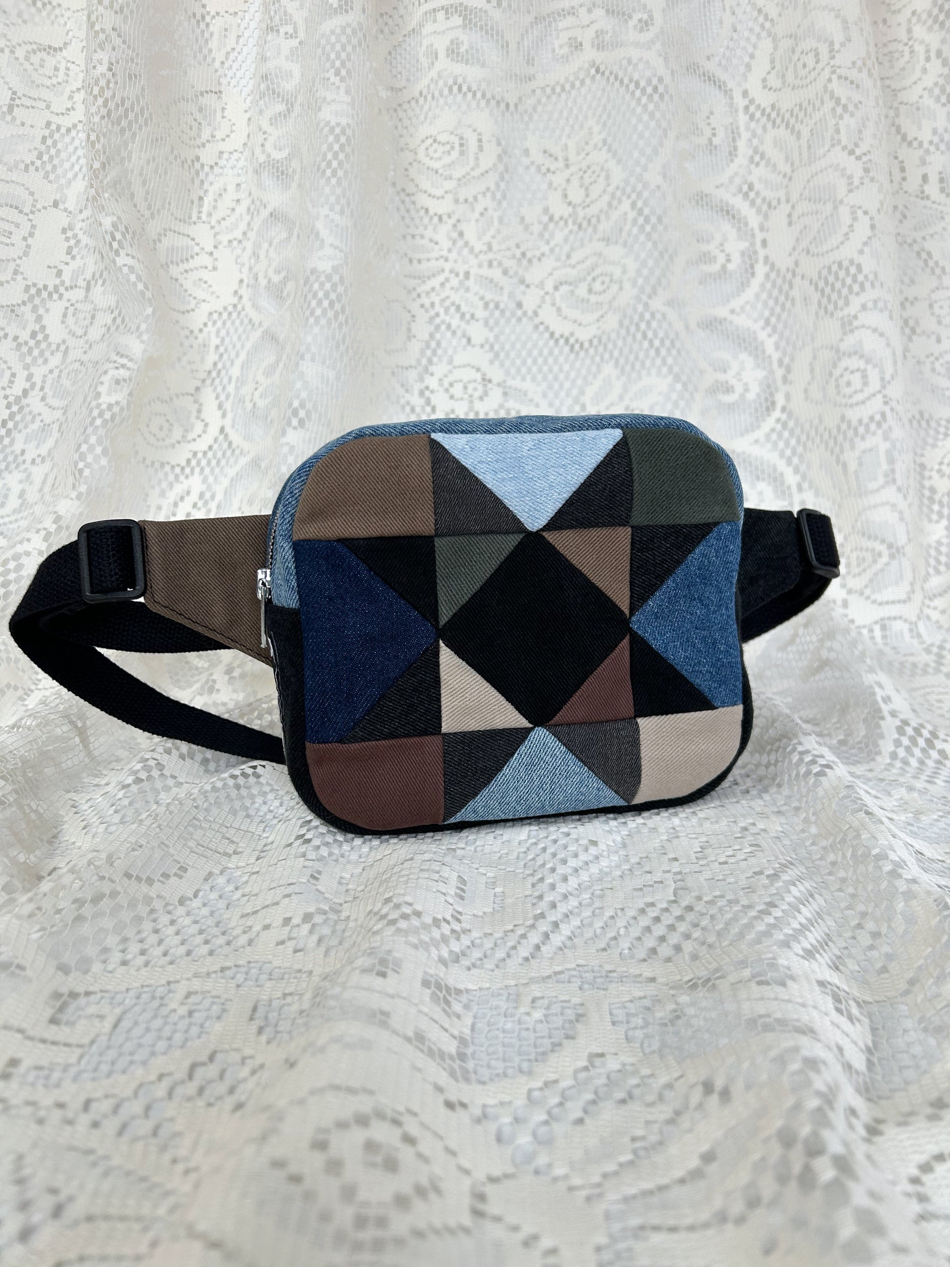 Multi-coloured denim fanny pack with a patchwork star pattern on a white lace background