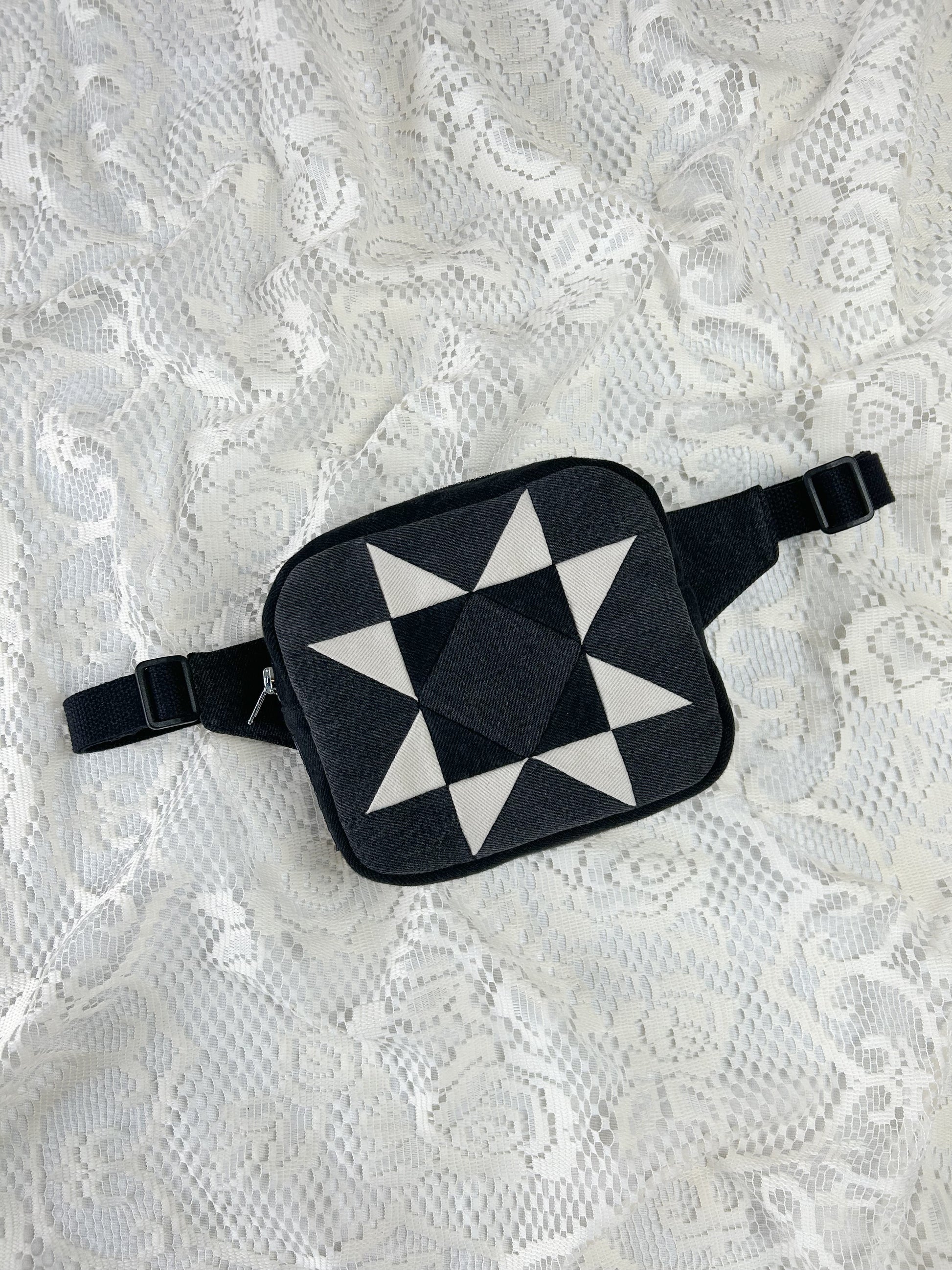 Grey, black and ivory denim fanny pack with a patchwork star pattern on a white lace background