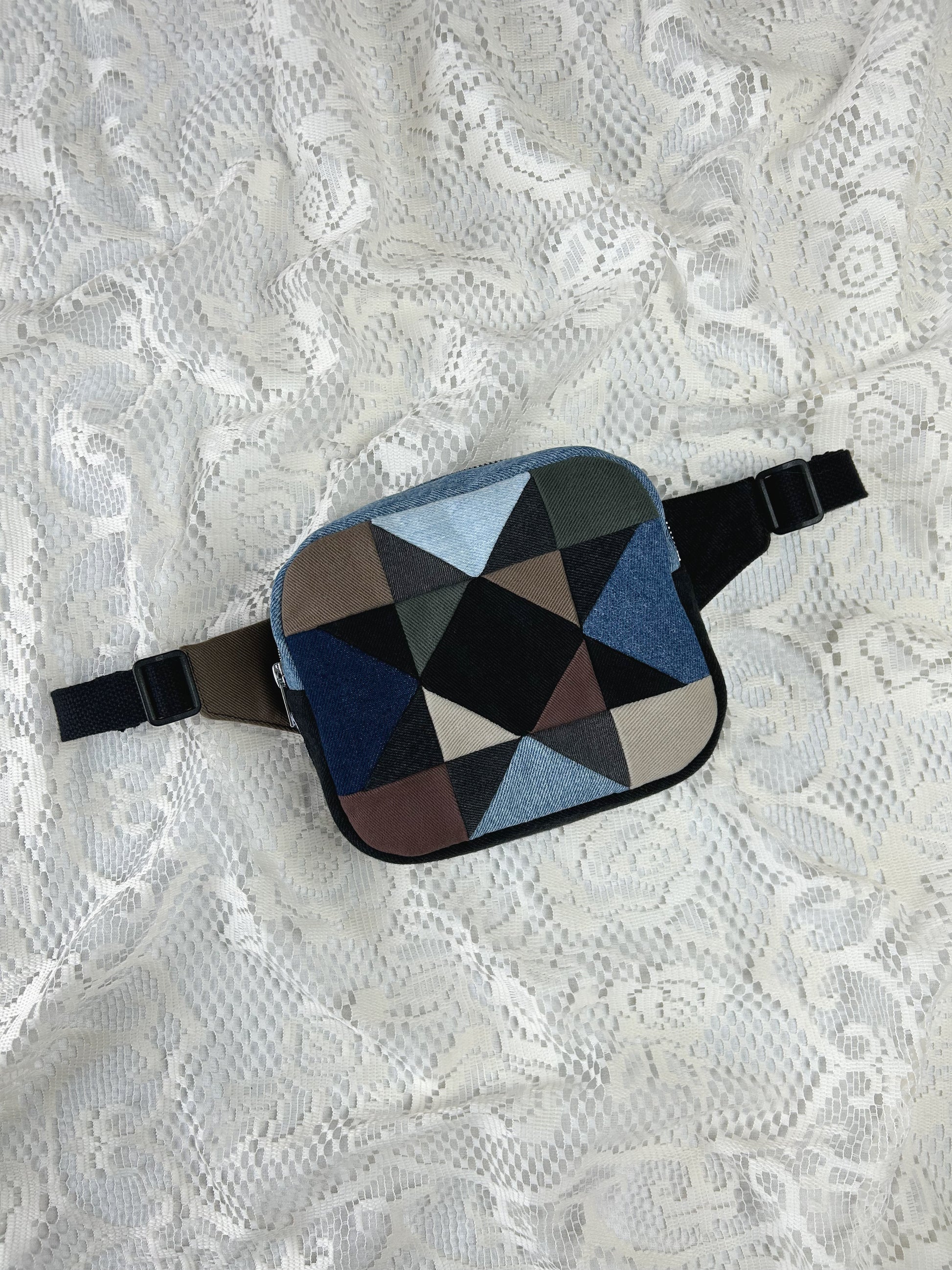 Multi-coloured denim fanny pack with a patchwork star pattern on a white lace background