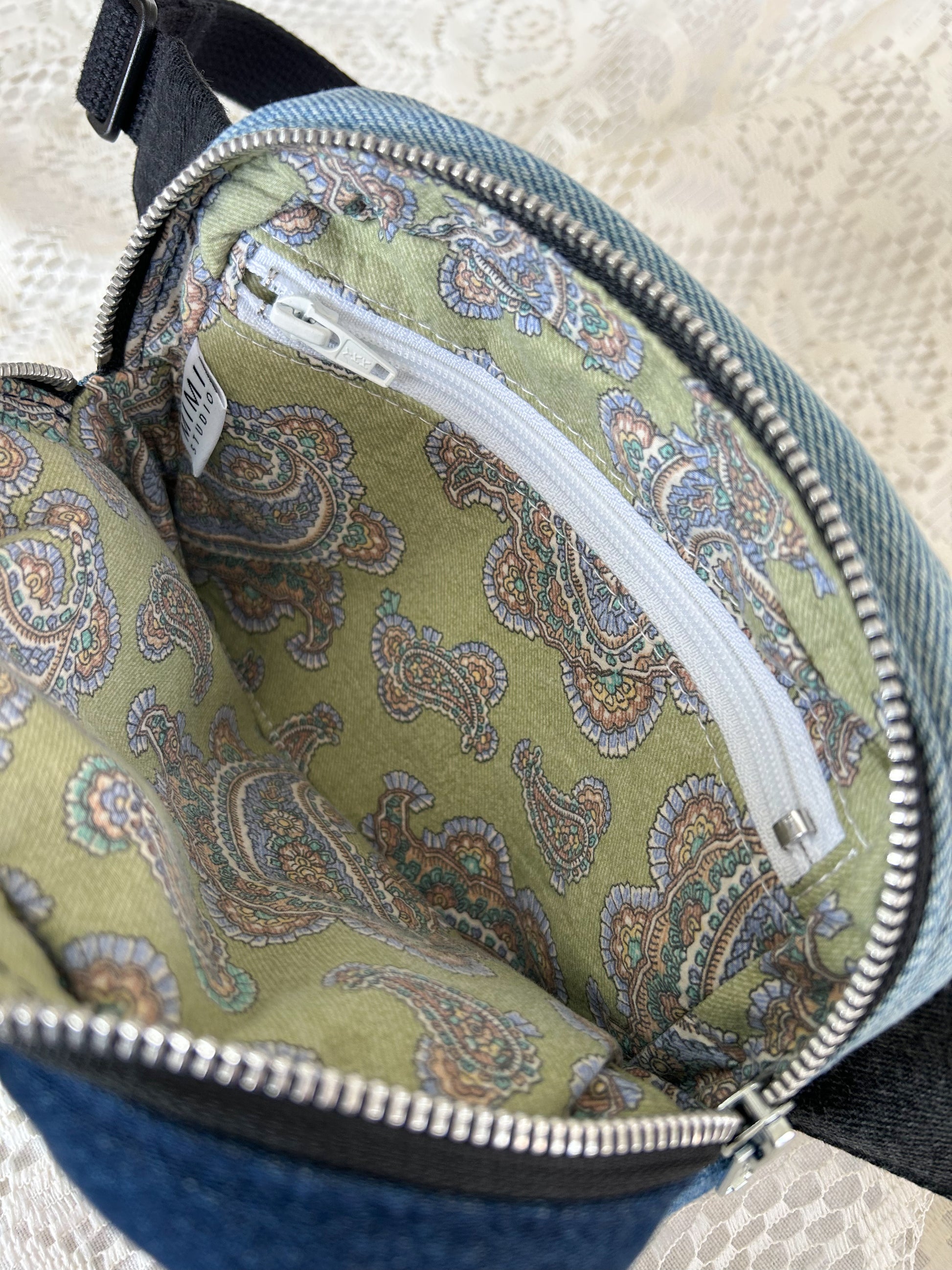 Paisley patterned interior lining of the fanny pack with a zippered pocket