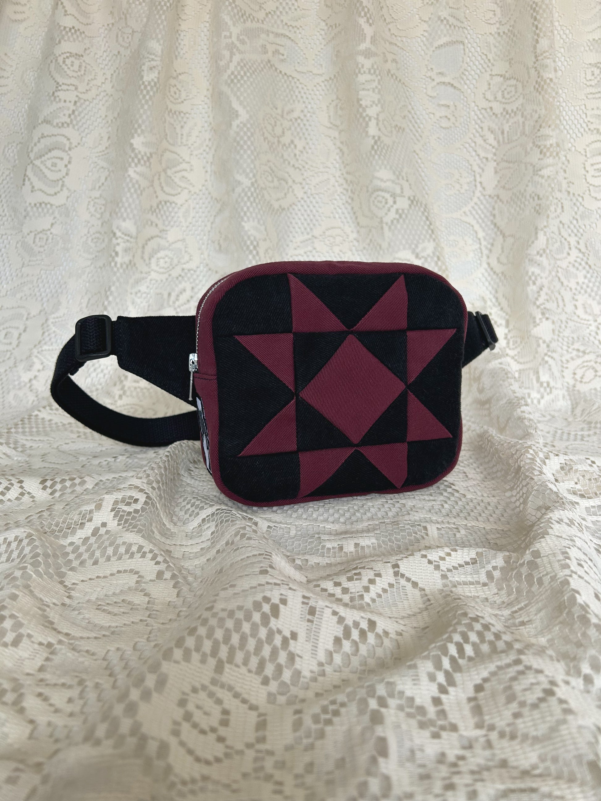 Front angled view of the same fanny pack with an ivory lace backdrop