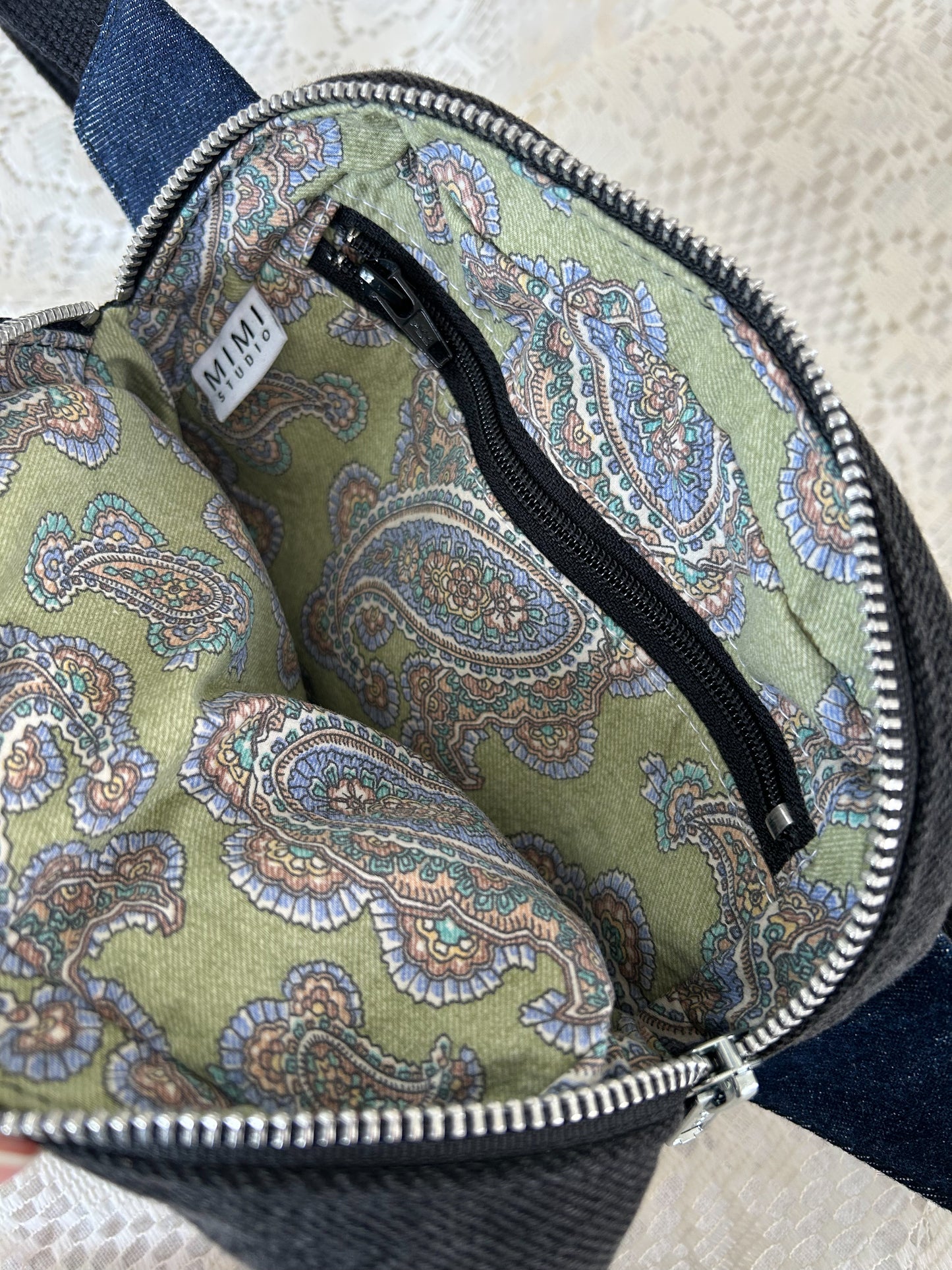 Paisley patterned interior lining of the fanny pack with a zippered pocket