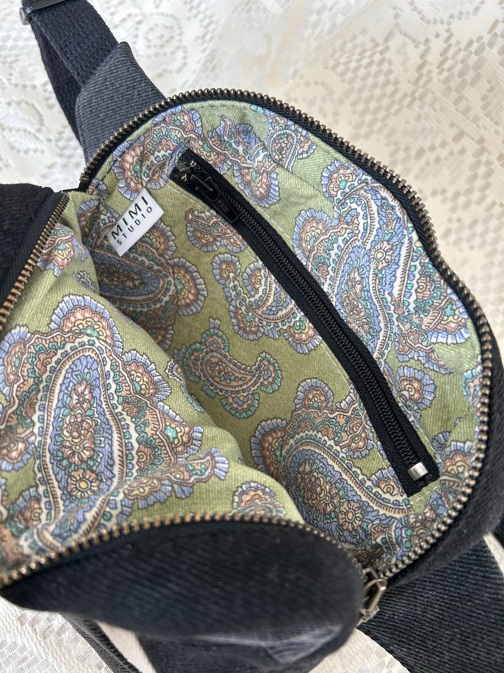 Paisley patterned interior lining of the fanny pack with a zippered pocket