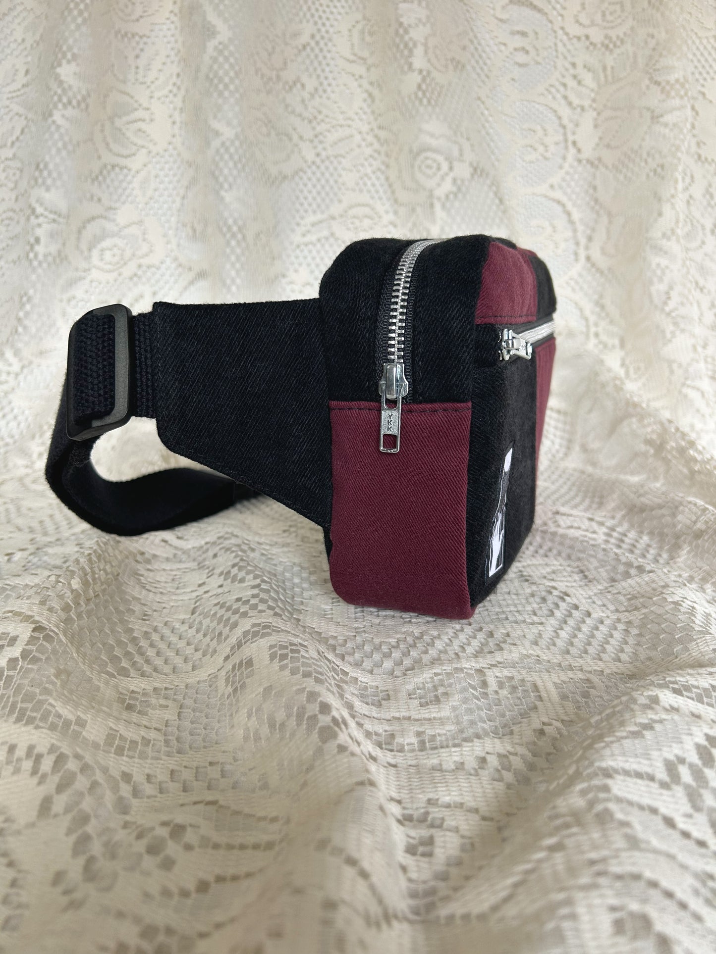 Side view of the same fanny pack showing the aluminum zipper with an ivory lace backdrop