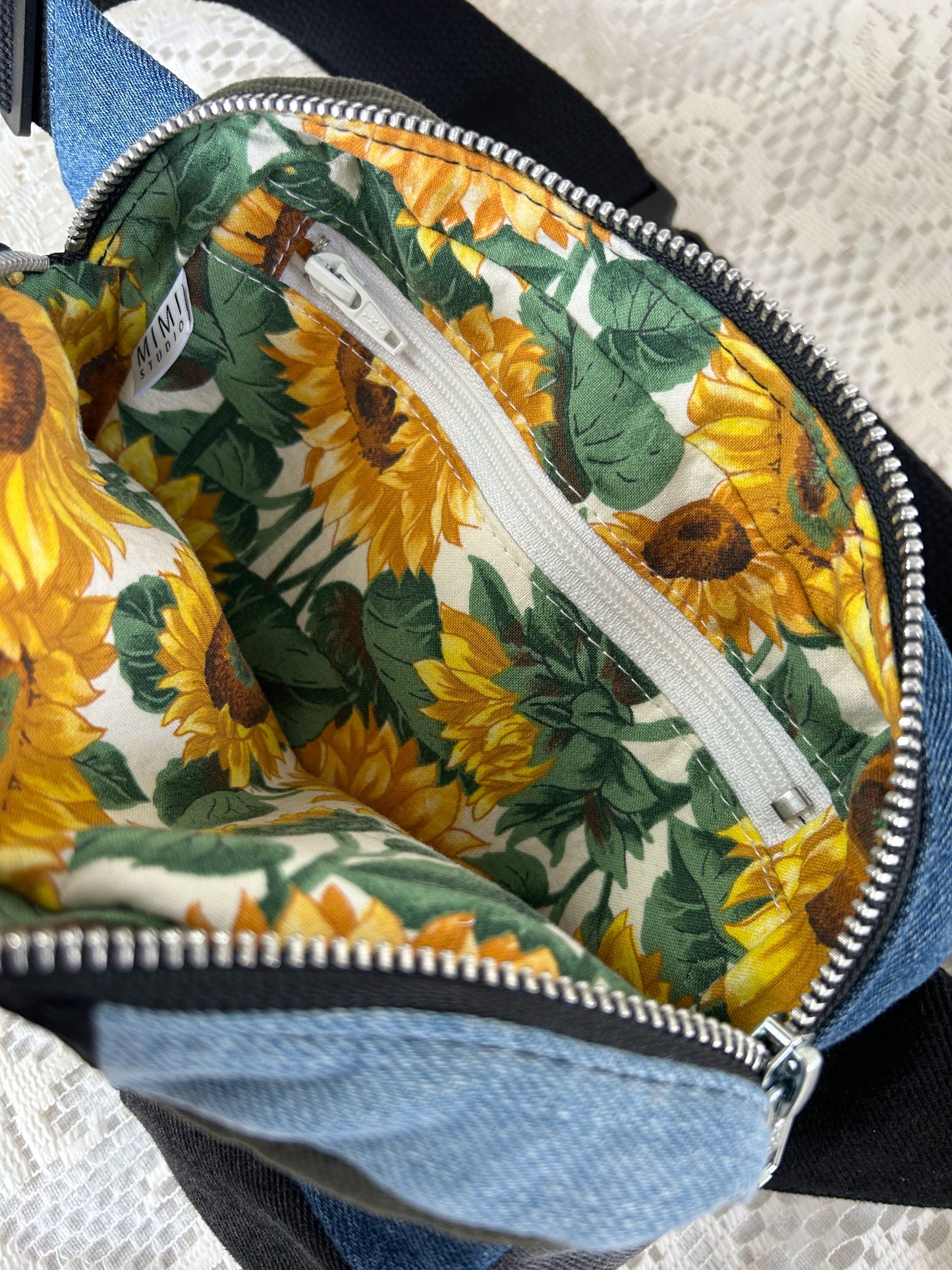 Sunflower patterned interior lining of the fanny pack with a zippered pocket