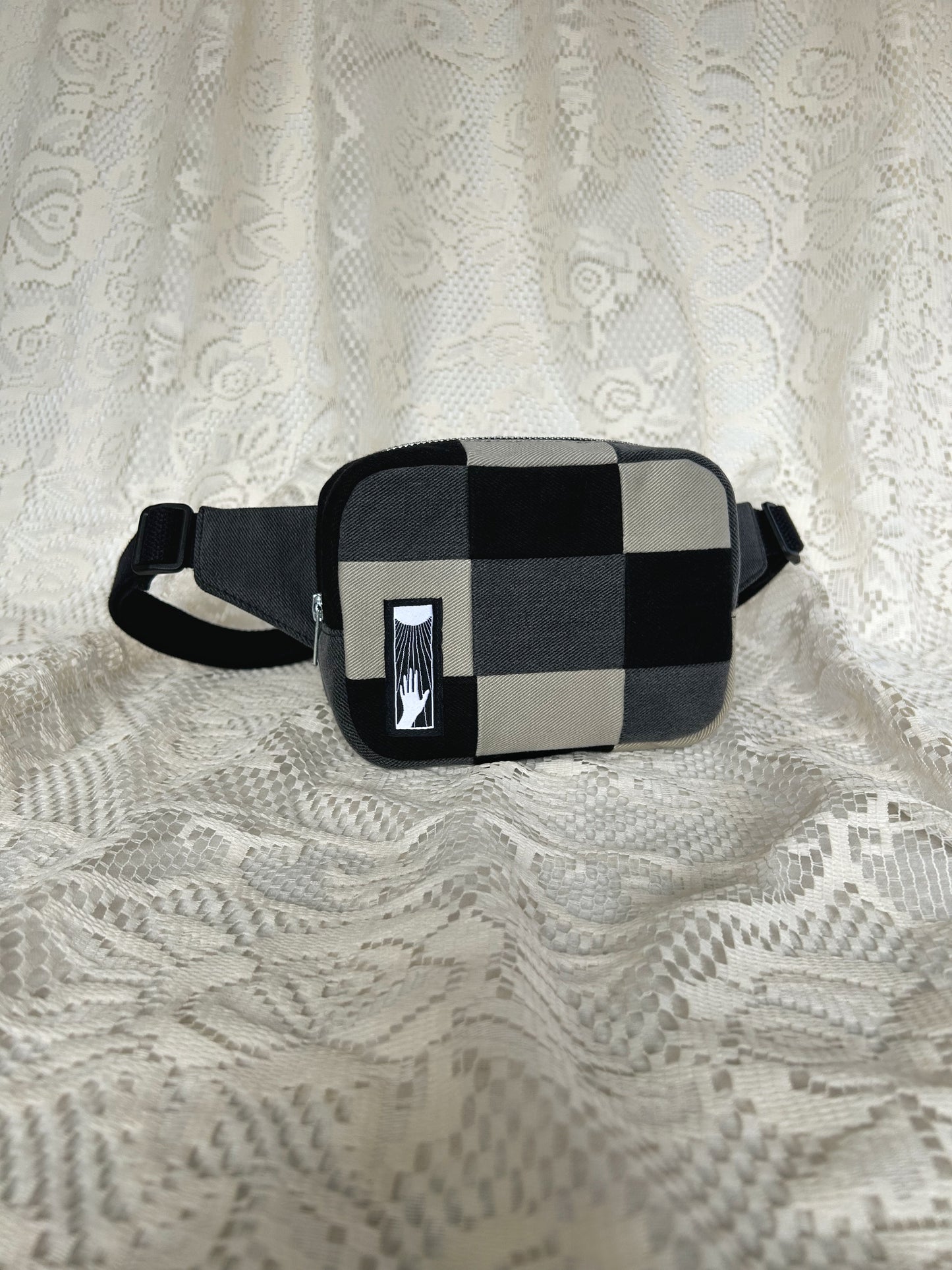 Front angled view of the fanny pack with an ivory lace backdrop