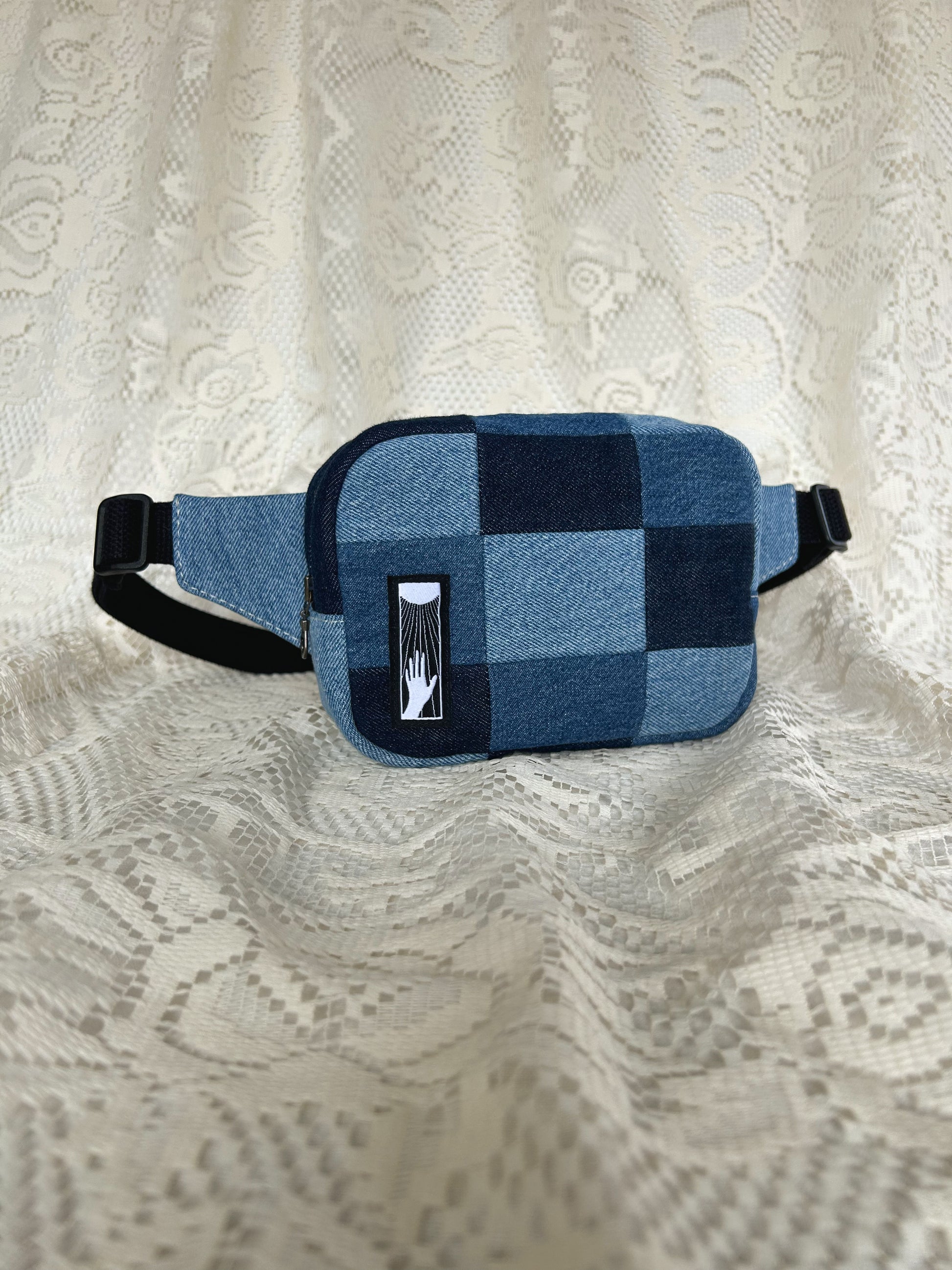 Front angled view of the same fanny pack with an ivory lace backdrop
