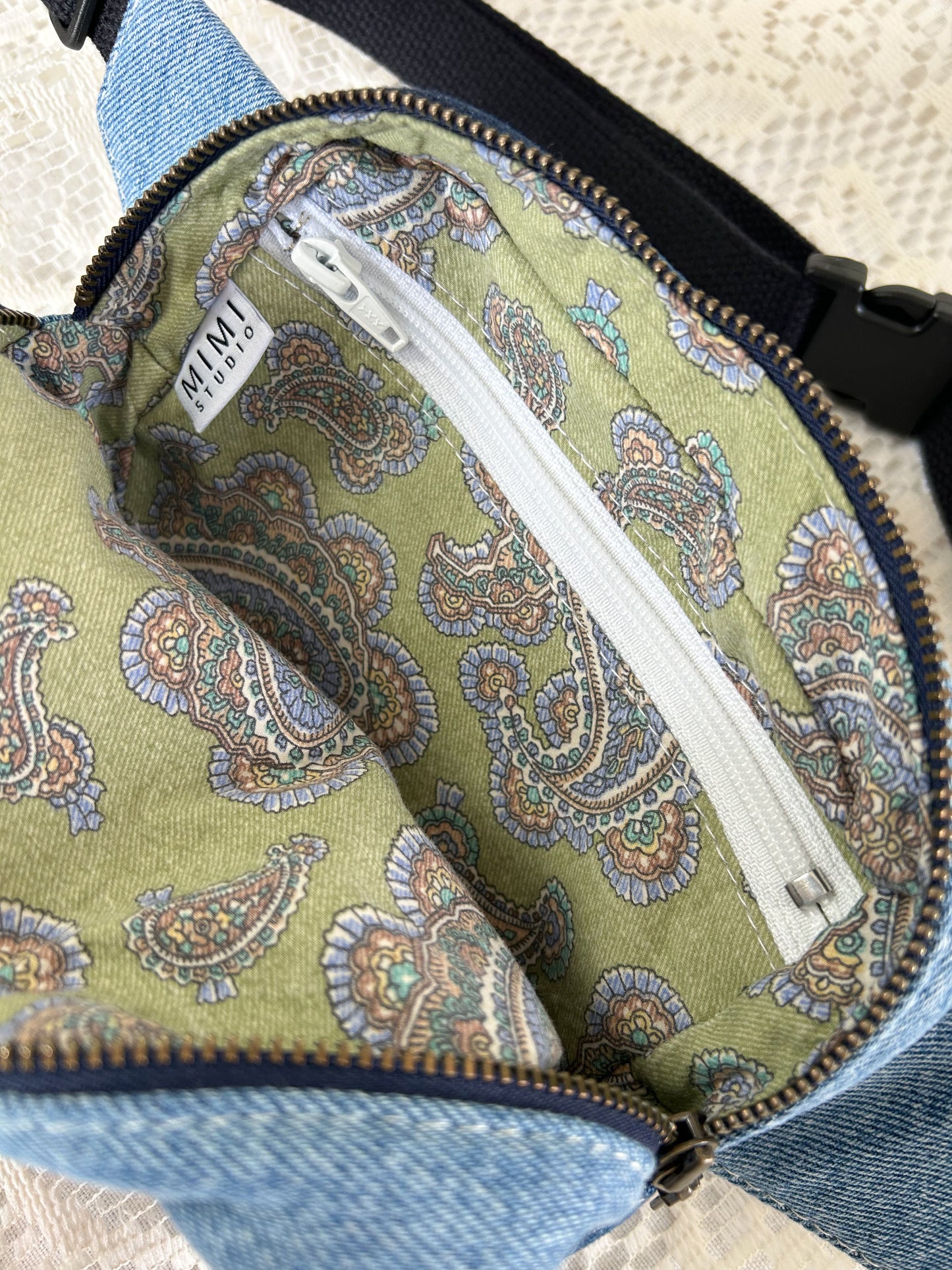 Paisley patterned interior lining of the fanny pack with a zippered pocket