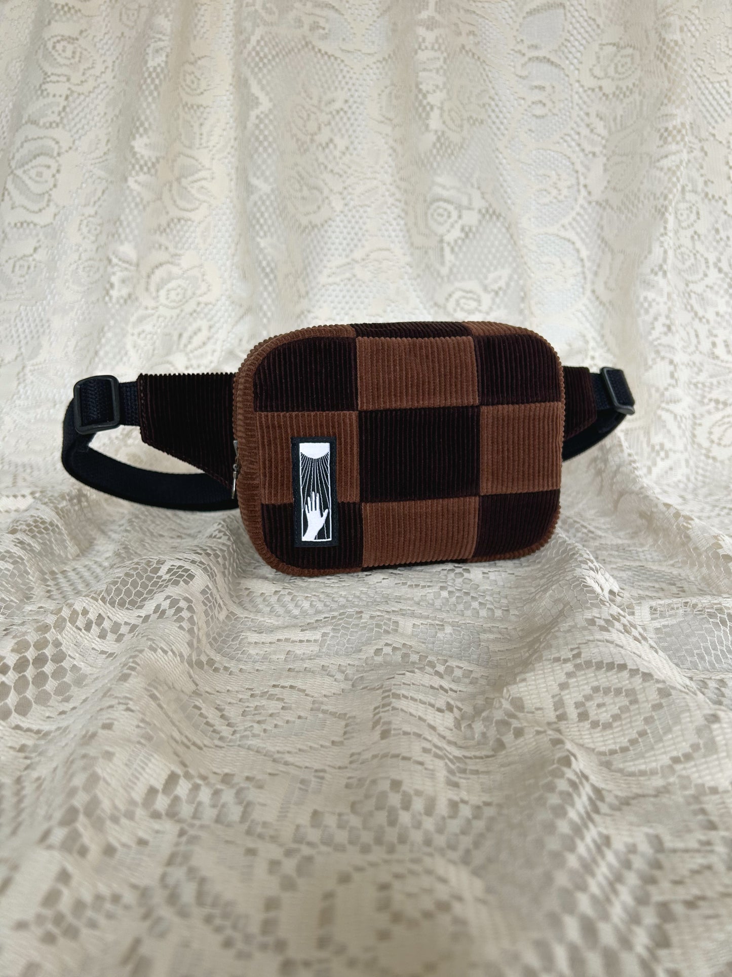 Front angled view of the same fanny pack with an ivory lace backdrop