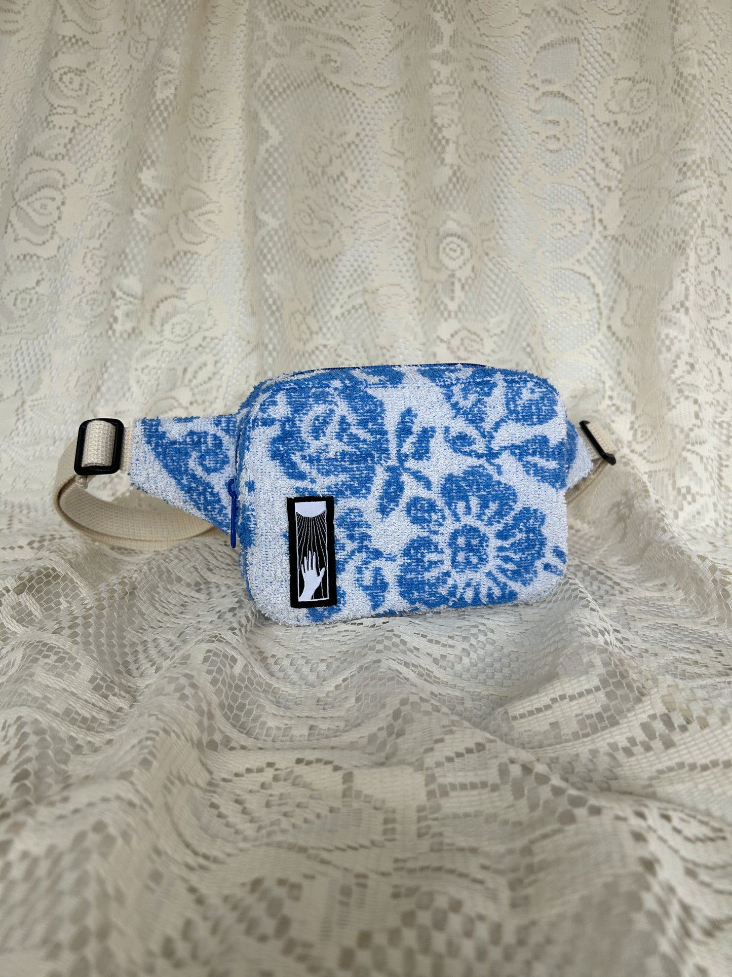 Front angled view of the same fanny pack with an ivory lace backdrop