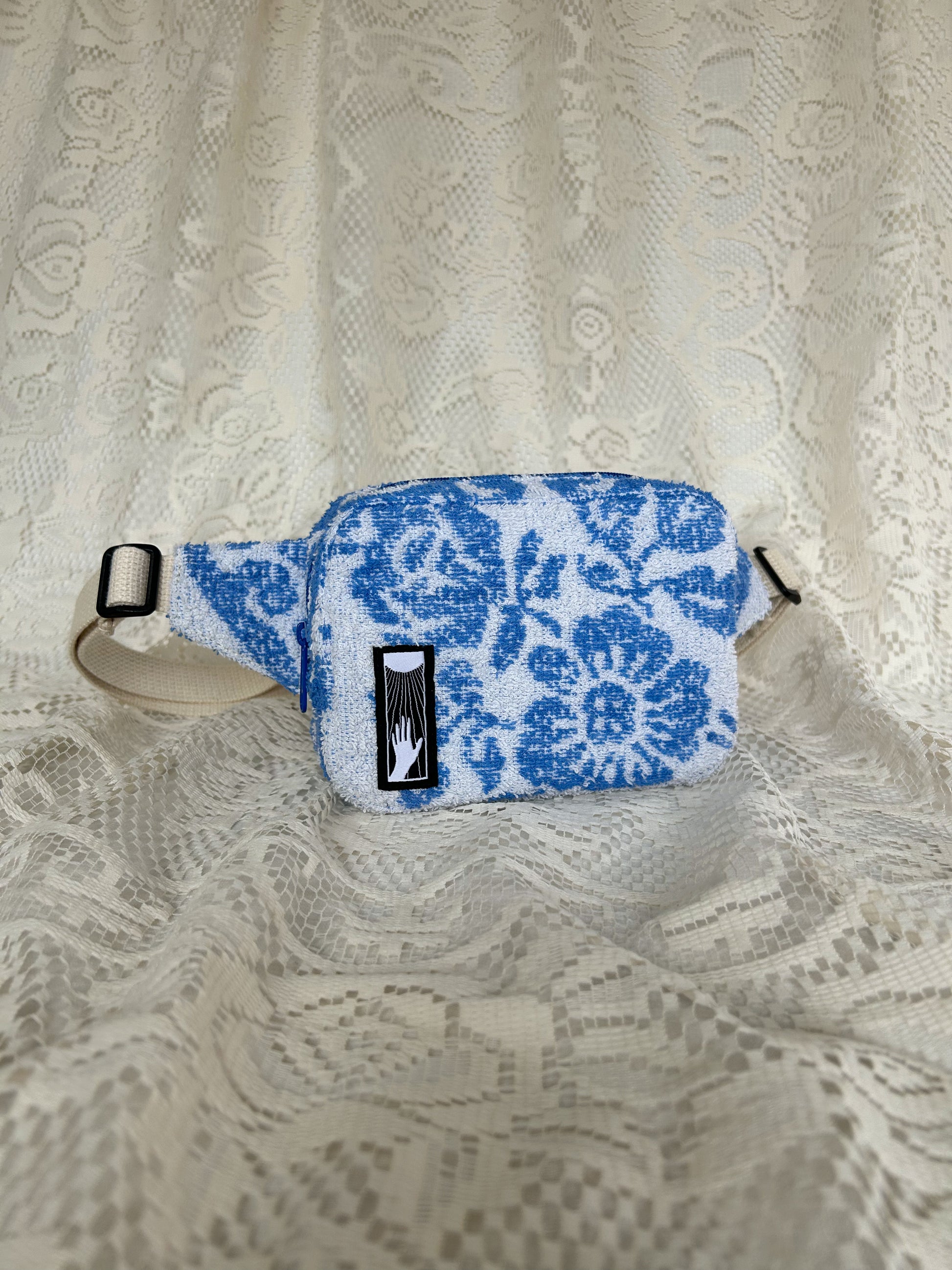 Front angled view of the same fanny pack with an ivory lace backdrop