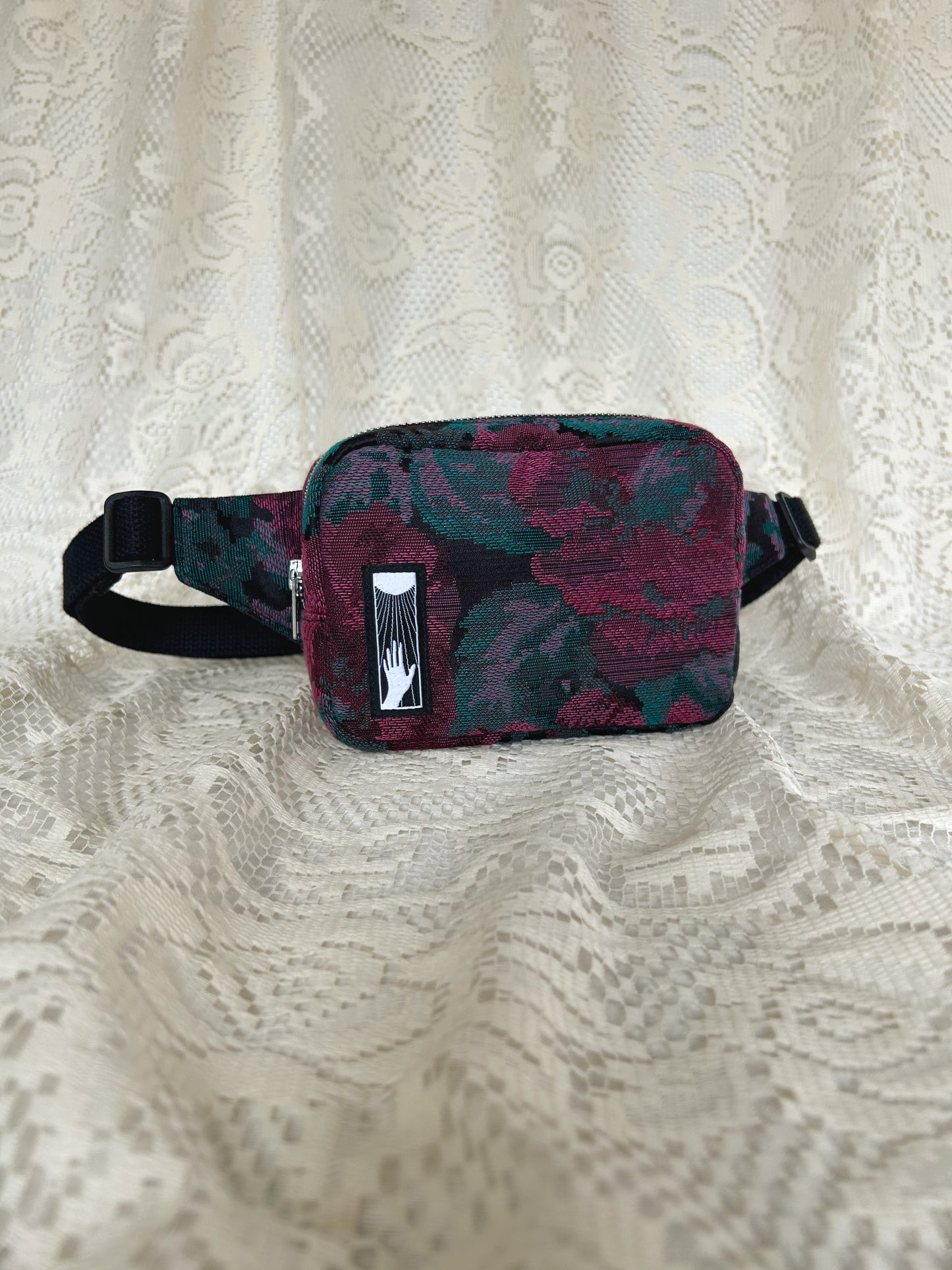 Front angled view of the same fanny pack with an ivory lace backdrop
