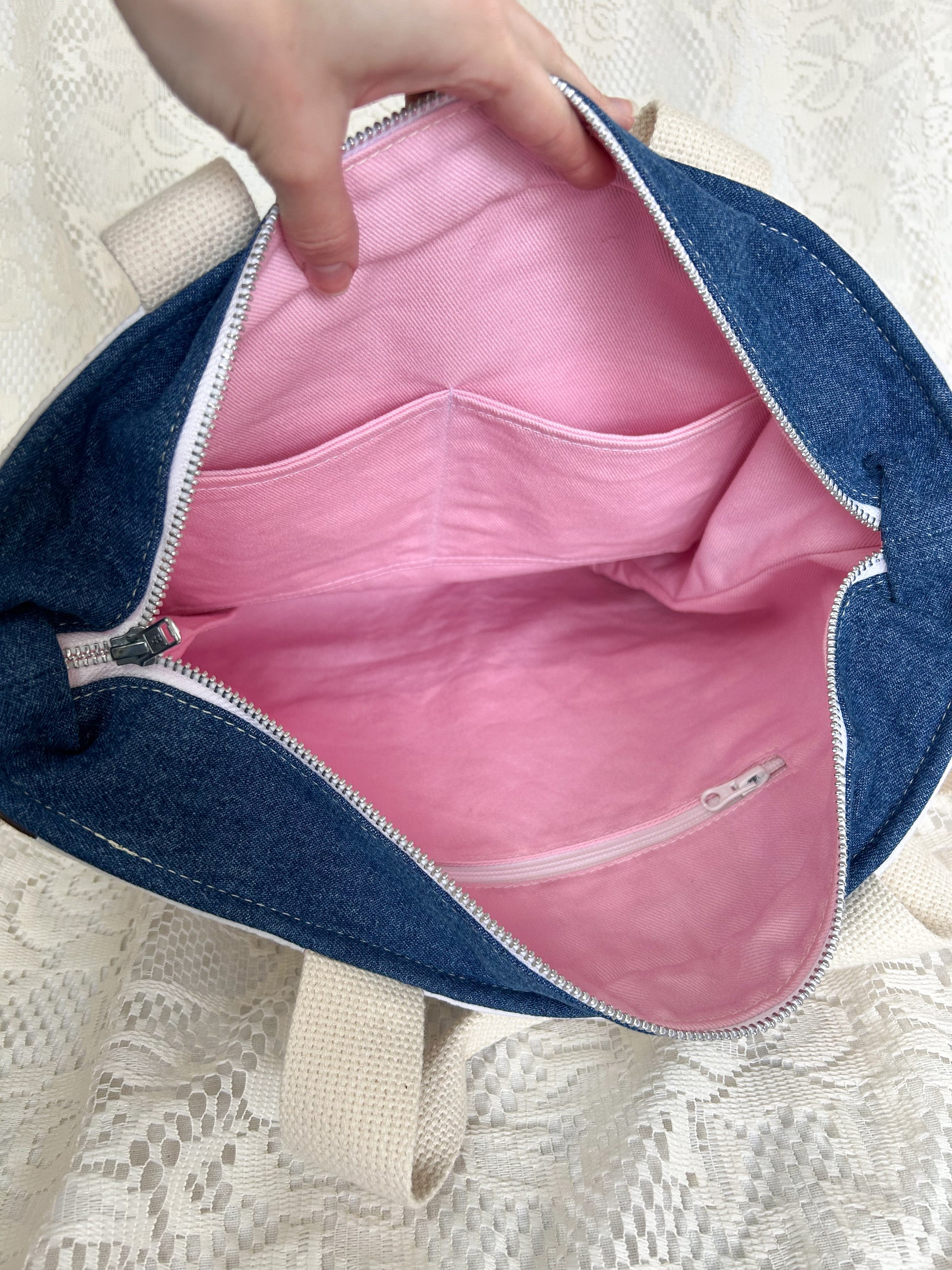 Pink canvas interior lining of the tote bag with one zippered pocket and two slip pockets