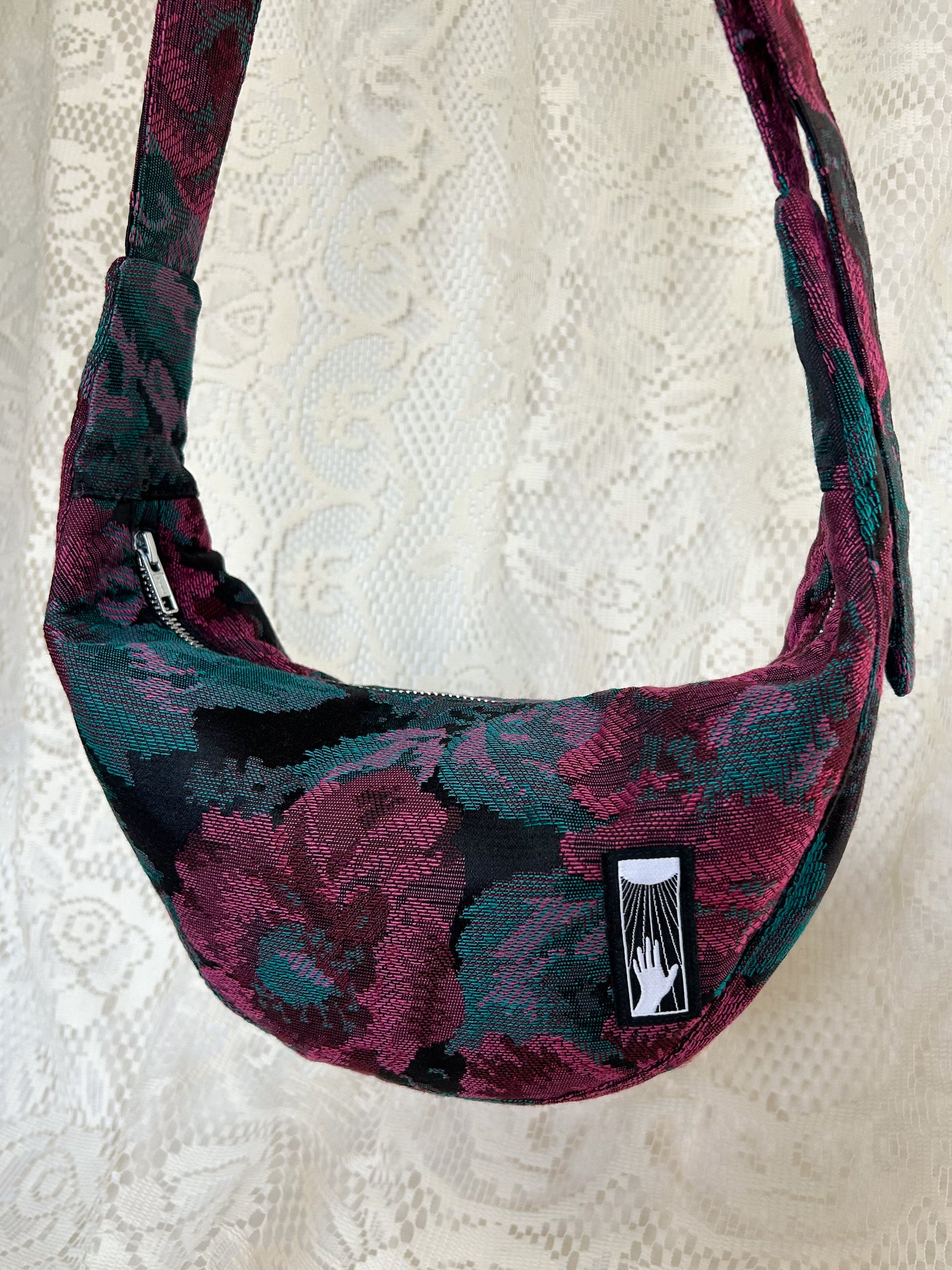Close up of the front of the crescent moon bag with an ivory lace backdrop