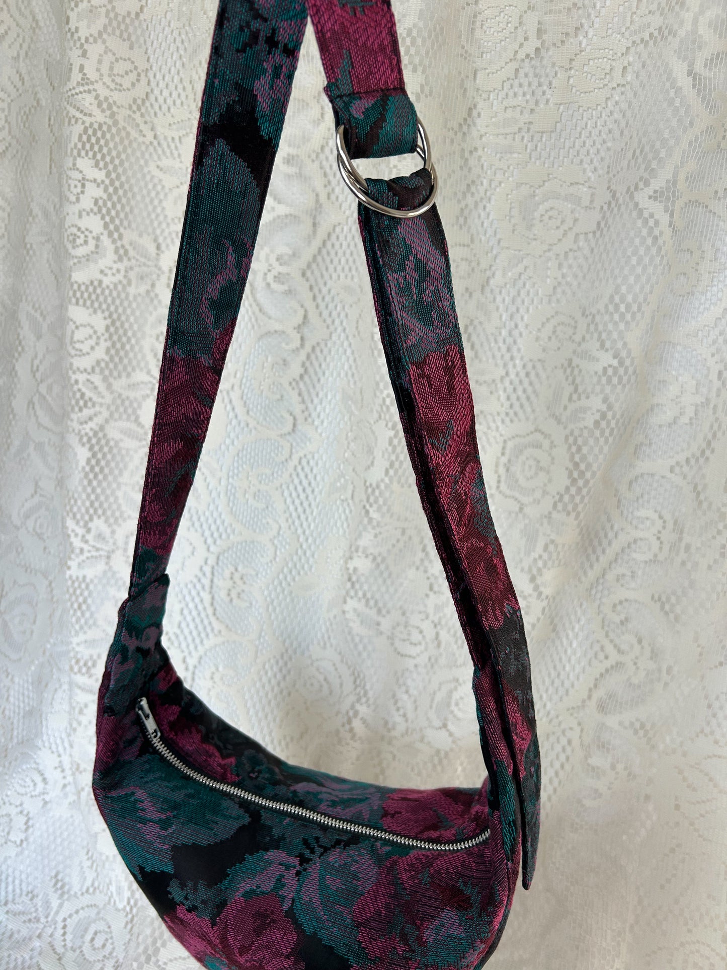 Strap and d ring hardware on the crescent moon bag with an ivory lace backdrop