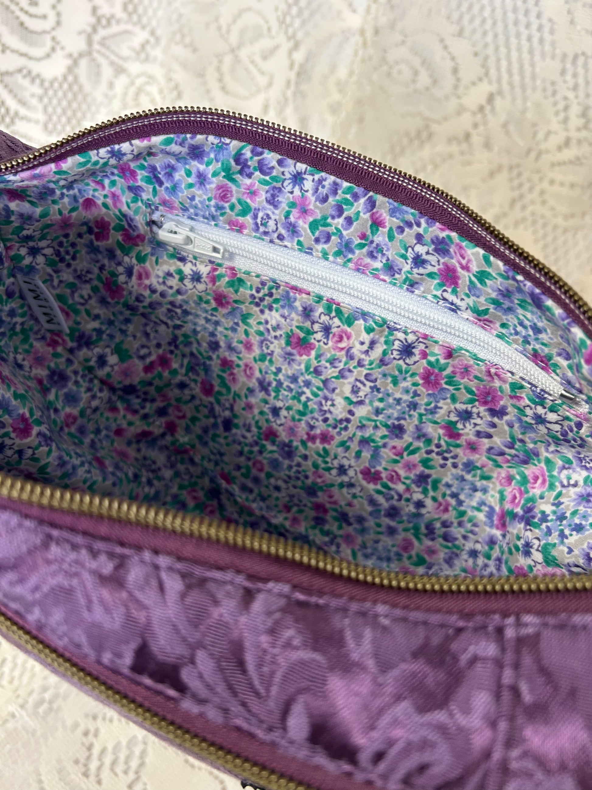 Floral patterned interior lining of the crescent moon bag with a zippered pocket