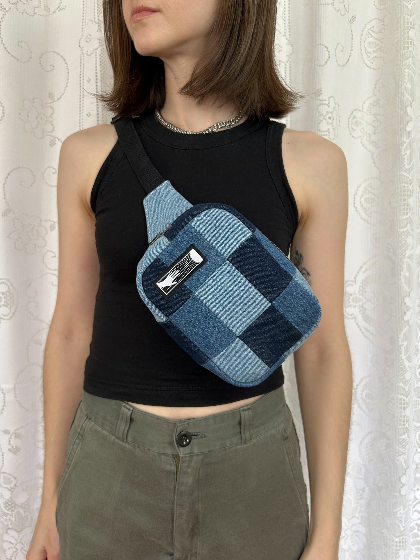 Woman wearing the same fanny pack cross-body in front of a white lace backdrop
