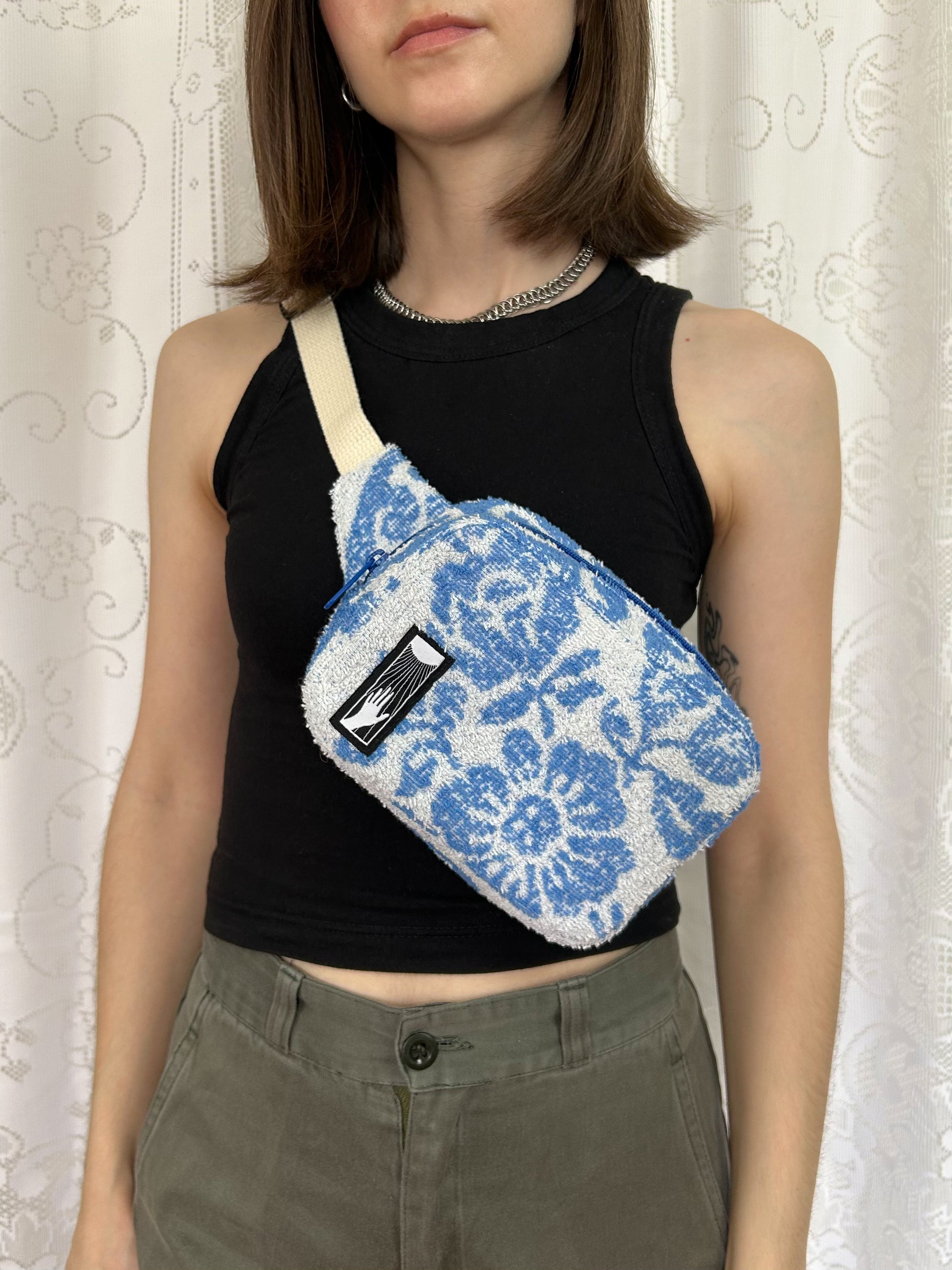 Woman wearing the same fanny pack cross body in front of a white lace backdrop