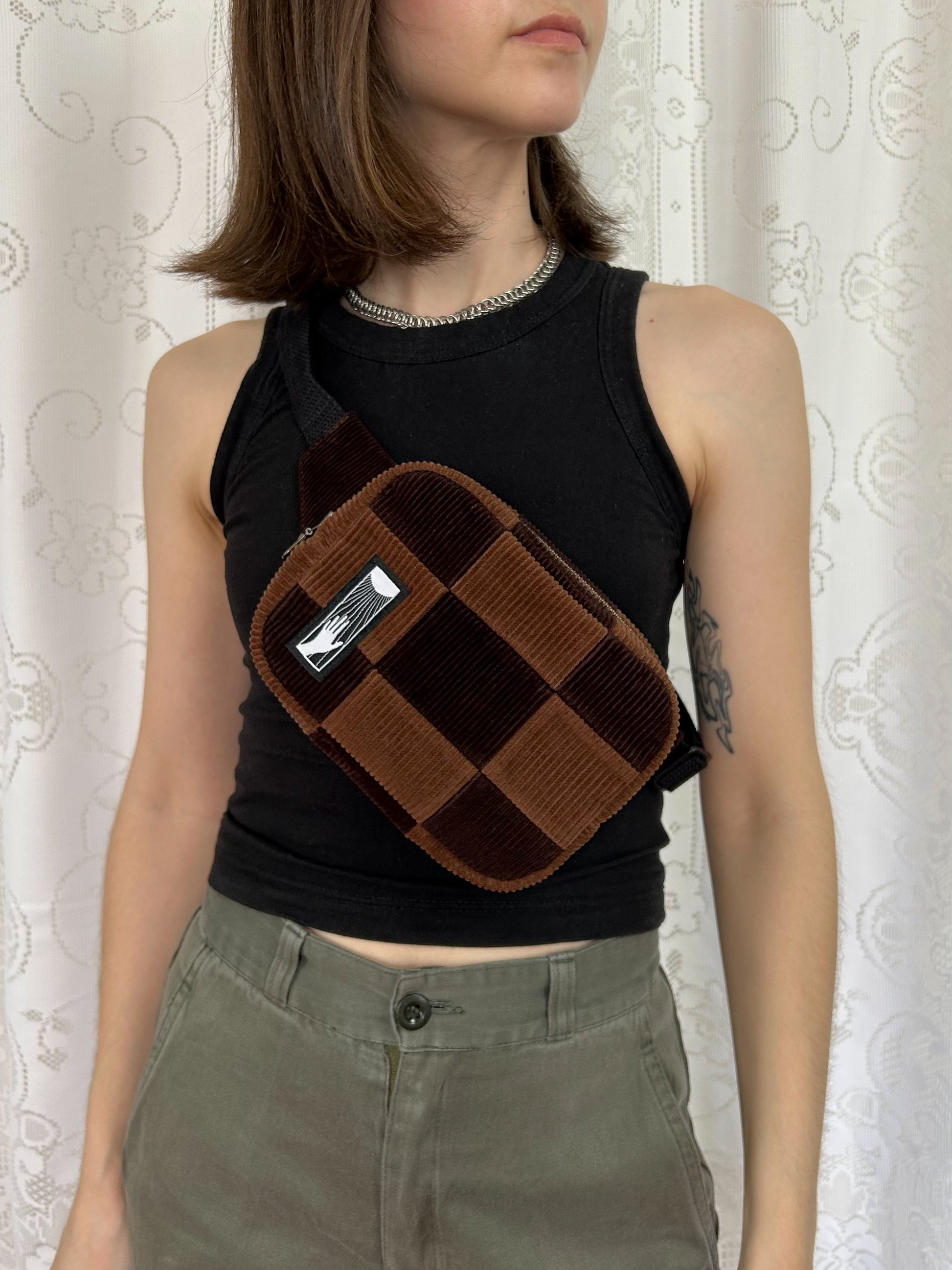 Woman wearing the same fanny pack cross-body in front of a white lace backdrop