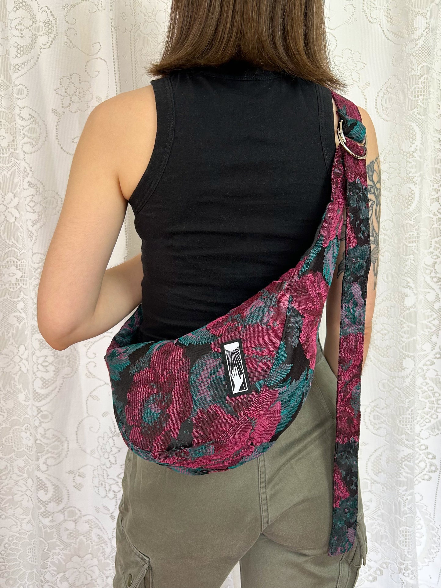 Second view of a woman wearing the crescent moon bag cross-body in front of a white lace backdrop
